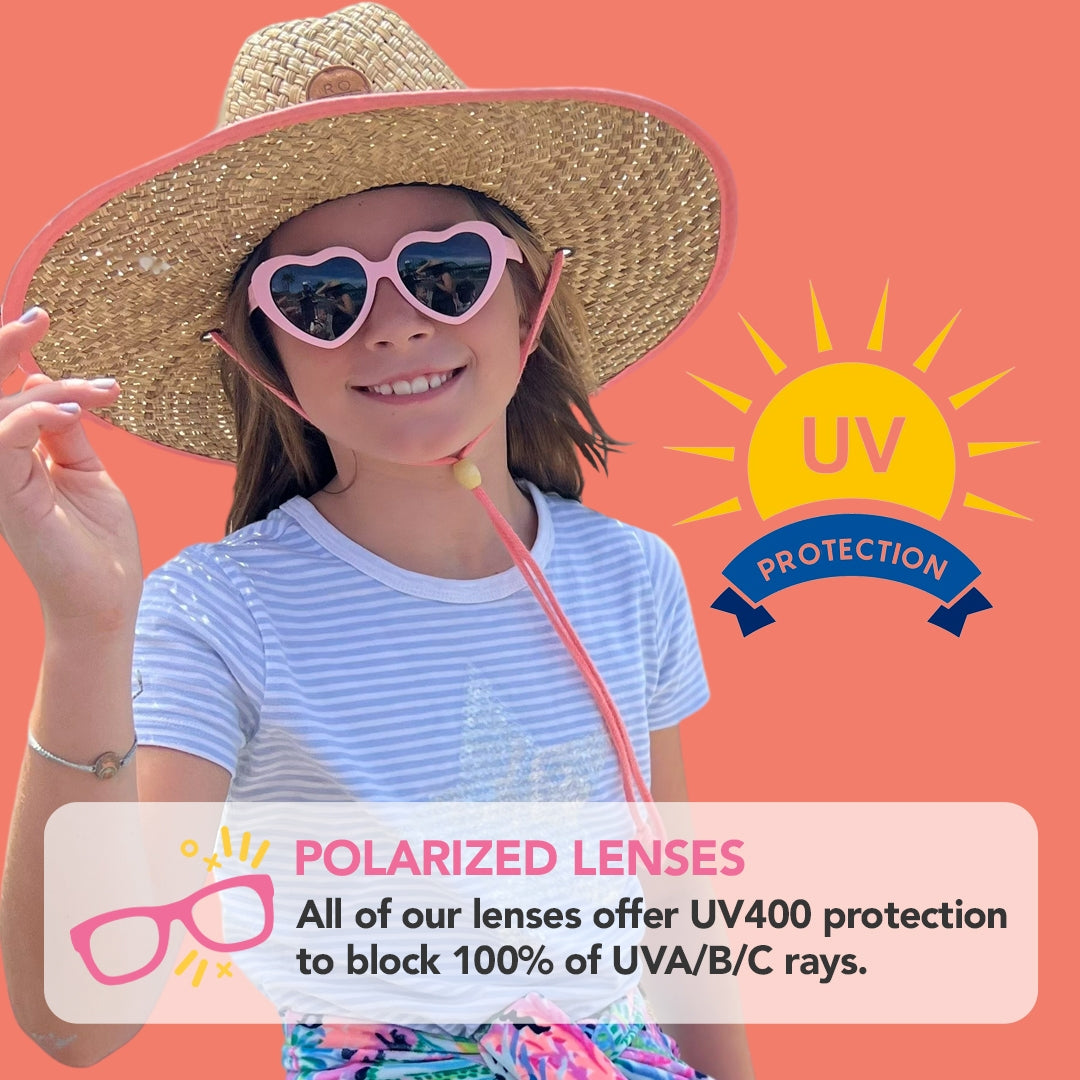Child wearing a straw hat and heart-shaped sunglasses with UV protection text on an orange background