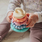 Child holding a colorful stacking toy with soft focus background