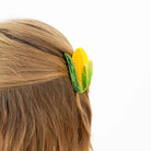 Corn-shaped hair clip on a person's hair against a white background