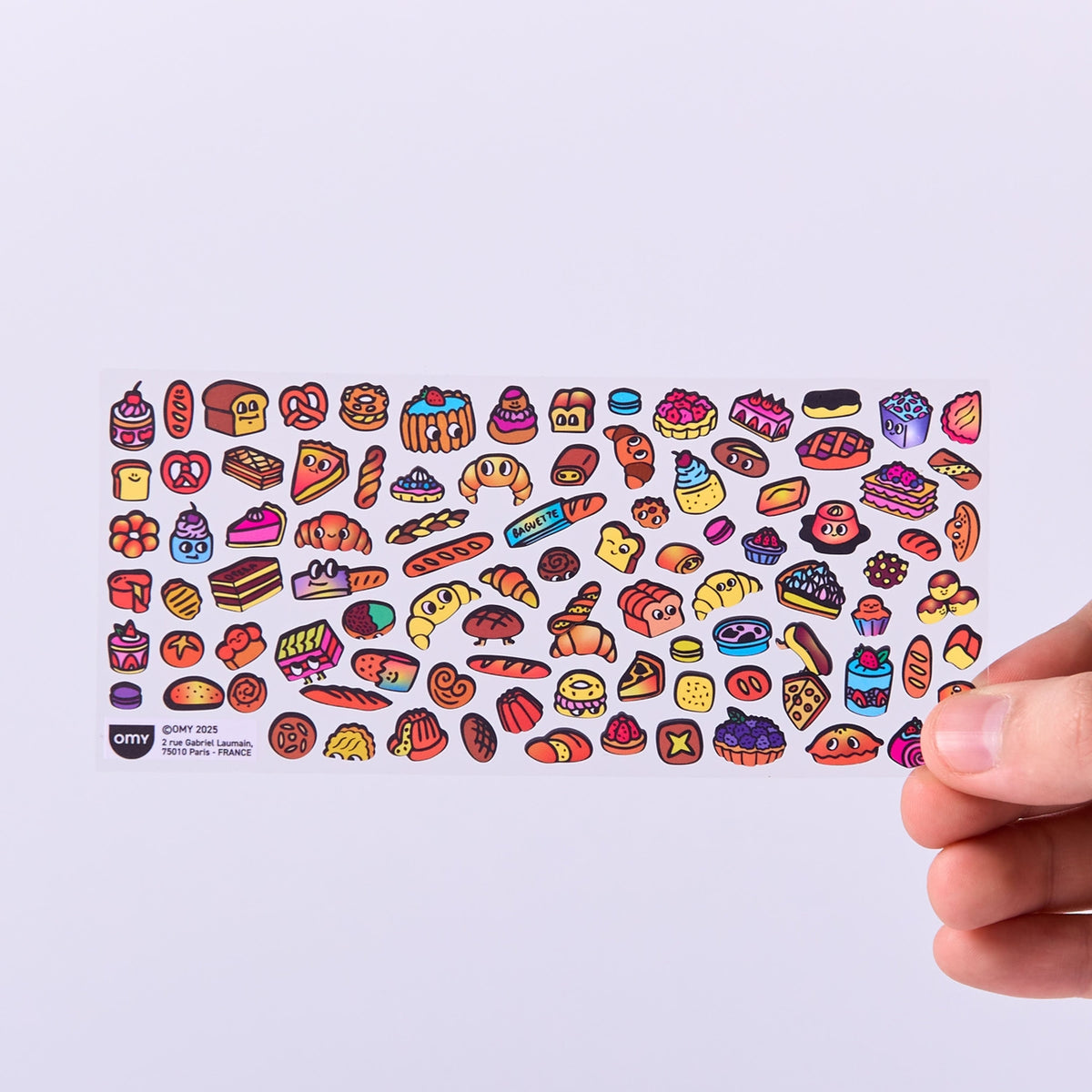 Colorful food-themed stickers held by a hand on a light purple background