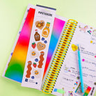 Pipstickers with a colorful gradient and a spiral-bound notebook on a green background