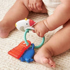 Baby playing with a colorful teething toy on a soft surface