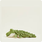 A green plush alligator toy with a textured, ribbed body and a white underbelly, lying on its side against a solid off-white background.