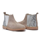 Pair of beige ankle boots with silver glittery panels on a white background