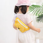 Child wearing a yellow bear-shaped fanny pack with a white background