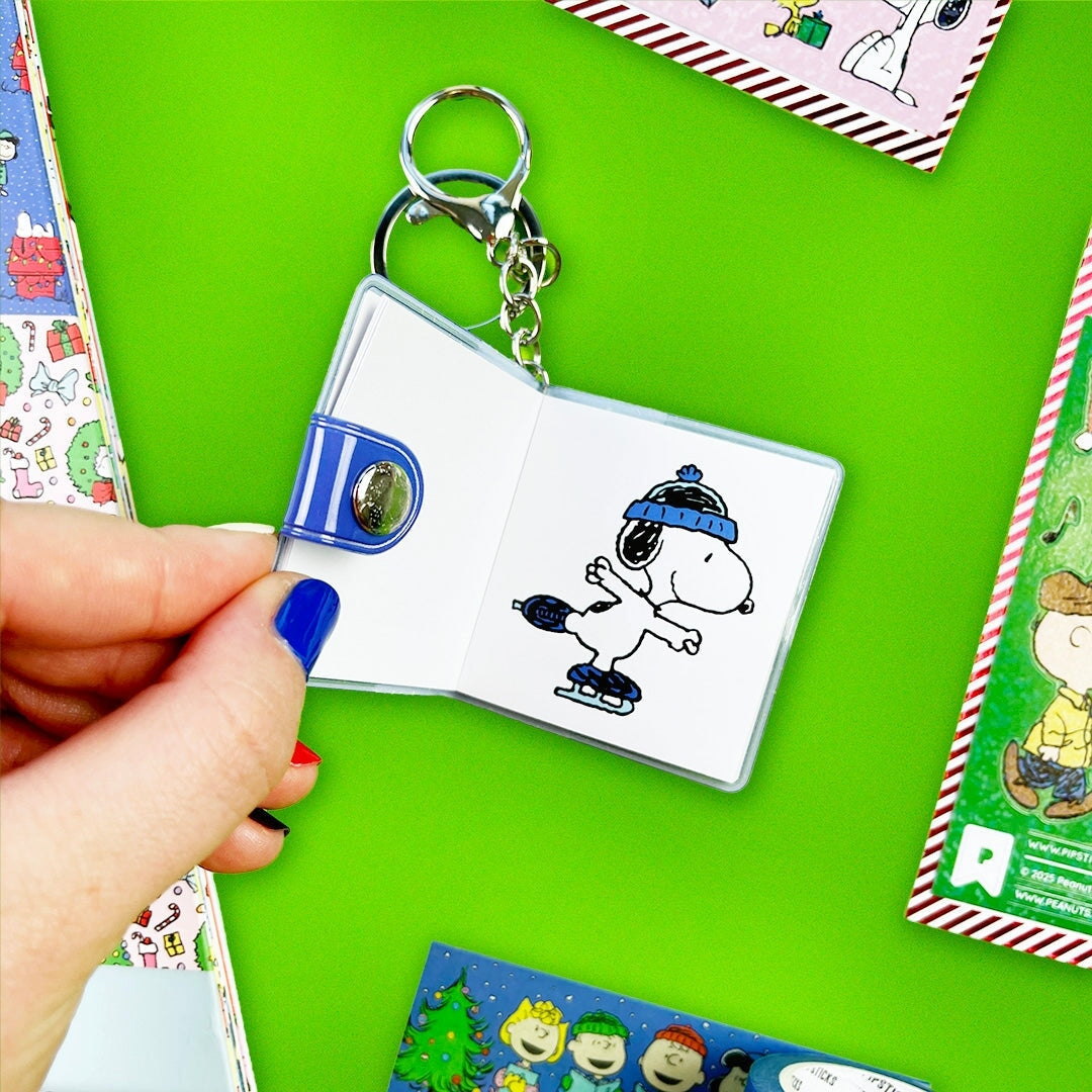Keychain with a small book featuring a cartoon character on a green background