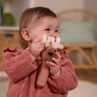 Child holding a plush toy with antlers indoors