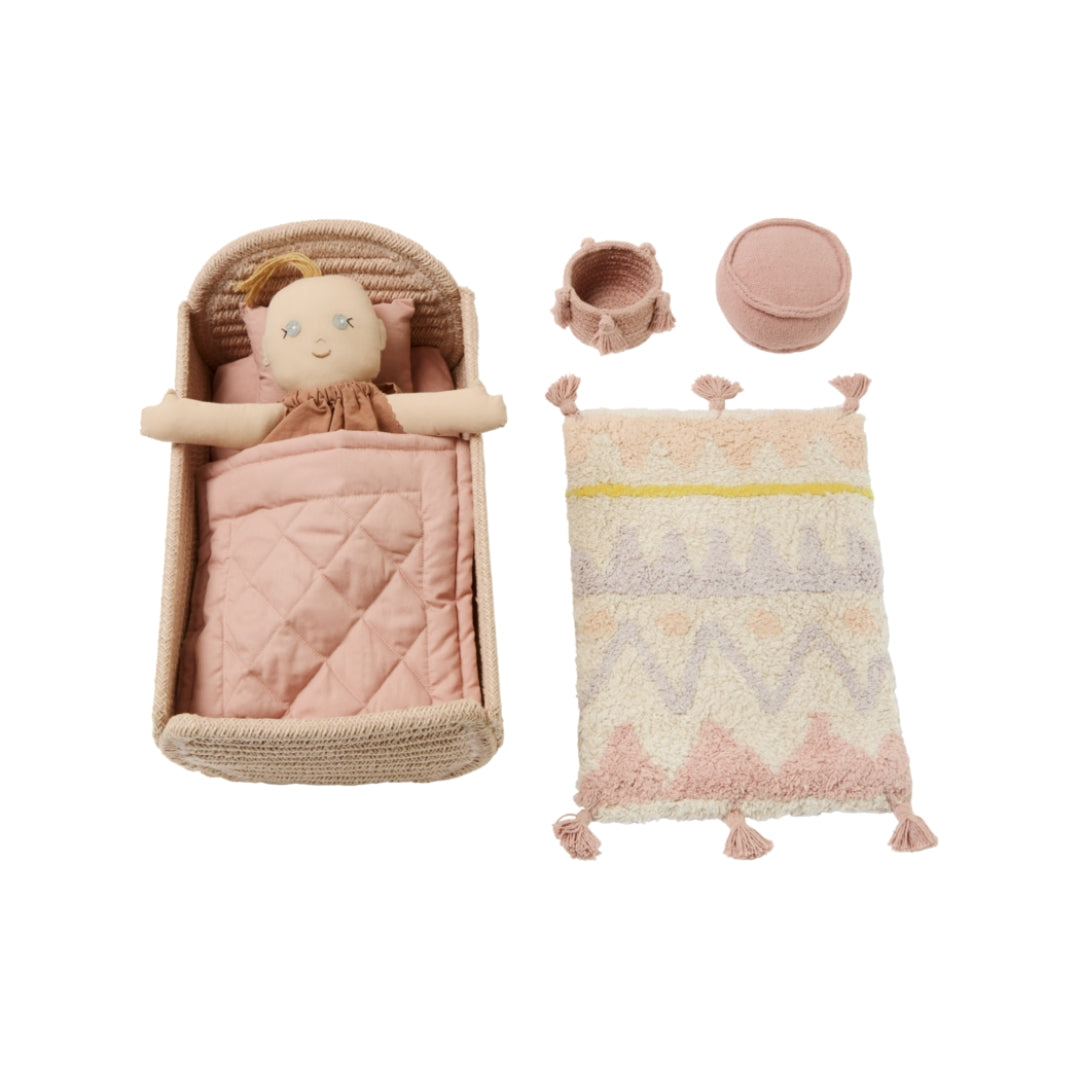 Baby doll with crib, blanket, and hat on a white background