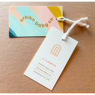 Urban Baby Co tag and card on a beige background