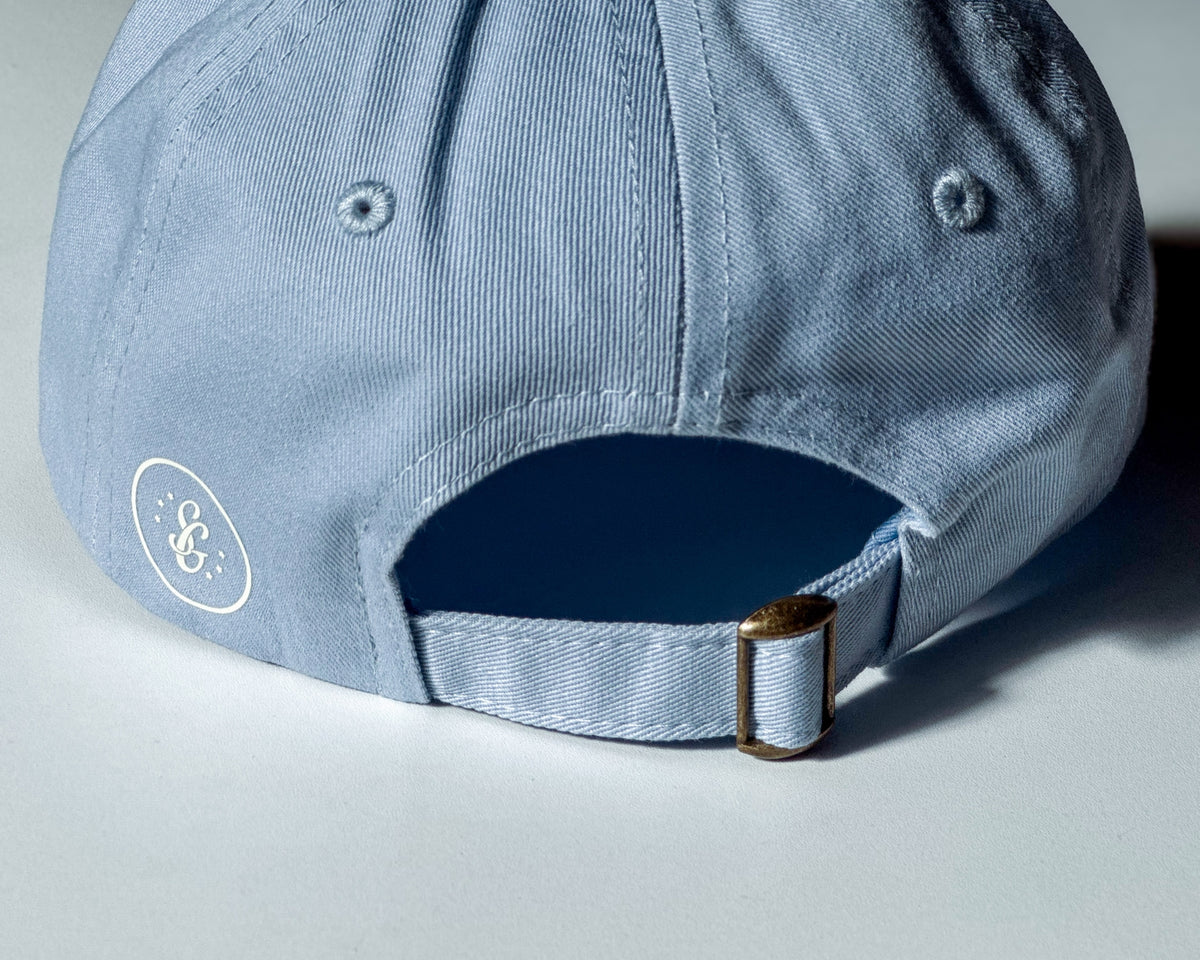 Light blue cap with a logo on the back against a light background