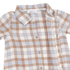 A close-up of a short-sleeve baby shirt by Toddler Dave, featuring a brown, white, and light blue gingham plaid pattern with a button-down front.