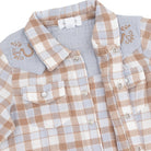 Close-up of a children's plaid button-front shirt with a light blue collar and embroidered details on the shoulders, shown on a white background.
