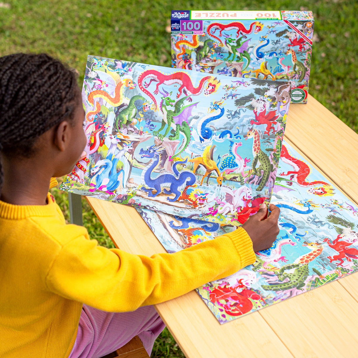 Child playing with a colorful puzzle on a wooden table outdoors