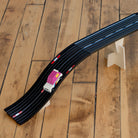 Toy race track set with cars on a brown    wooden floor