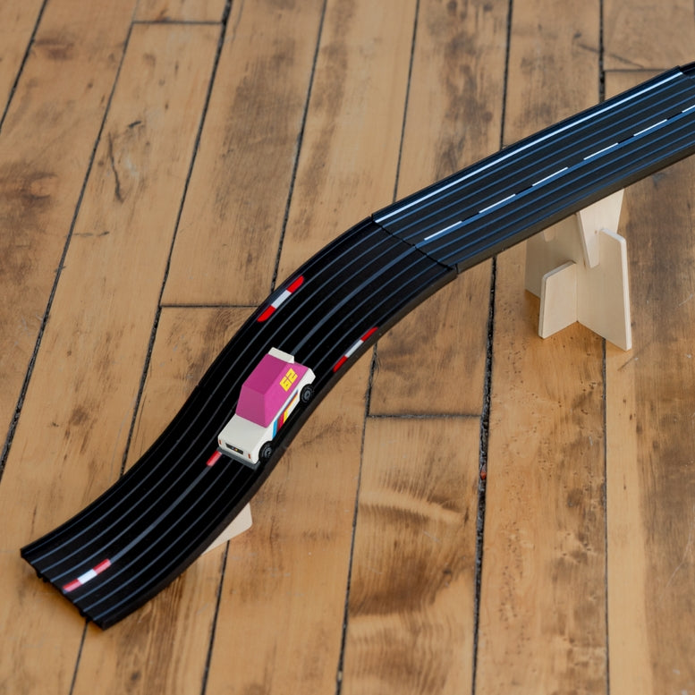 Toy race track set with cars on a brown    wooden floor