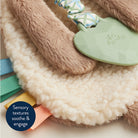 Sensory toy with textured elements and a plush surface on a light background