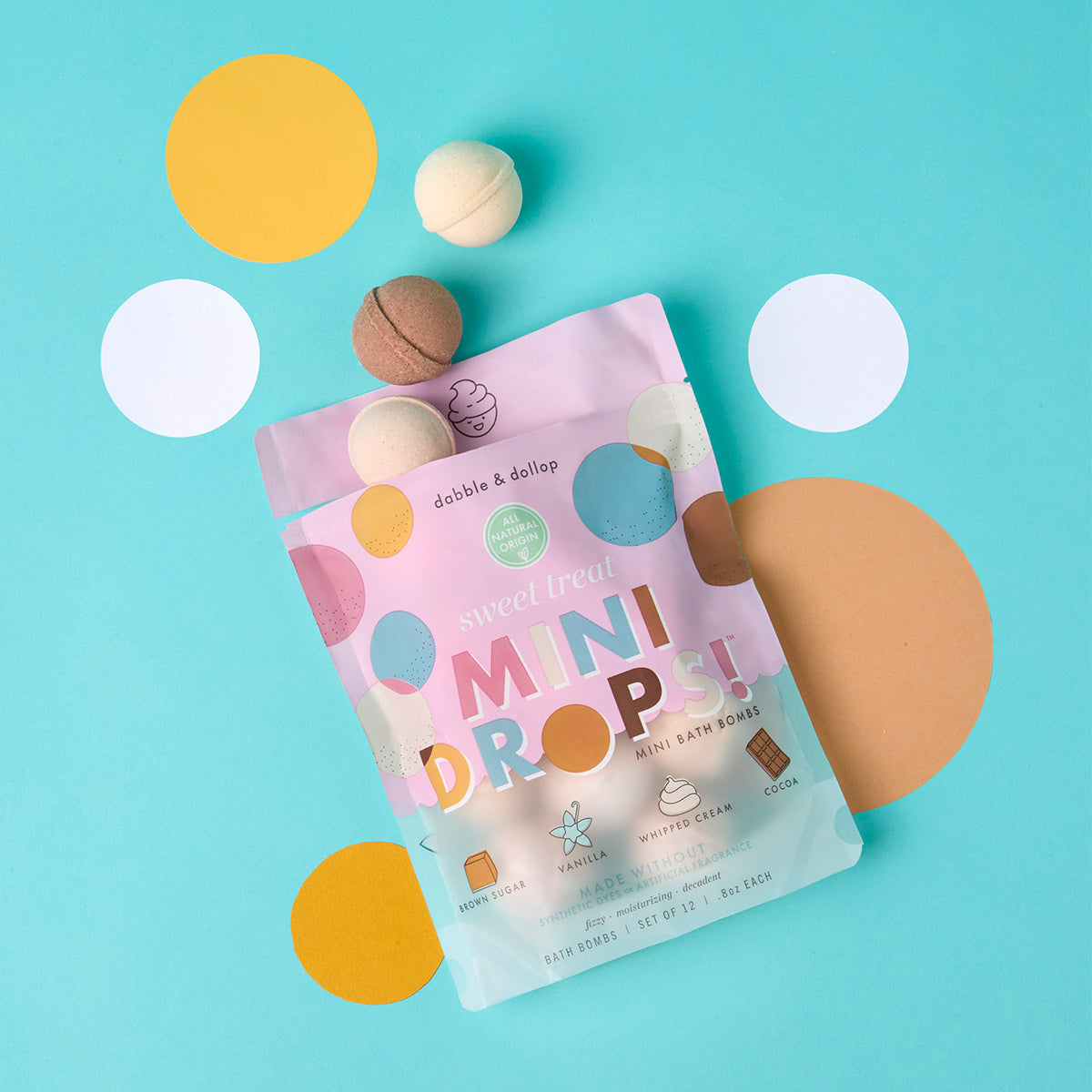 Packaging of 'Mini Drops' with bath bombs on a blue background