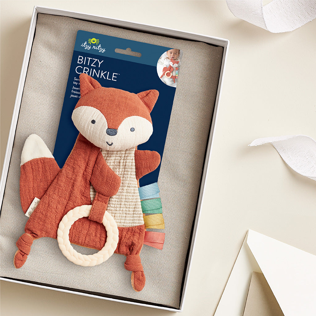 Fox-shaped baby rattle with crinkle sound inside a box, featuring its packaging.