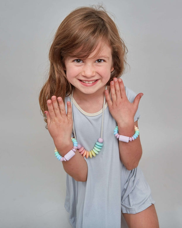 Young girl in a light blue dress posing against a plain background