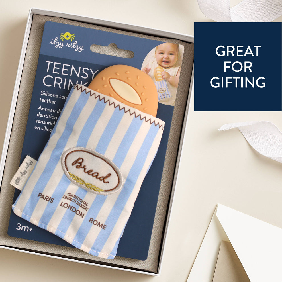 Baby teether with packaging labeled 'itzy ritzy' on a white surface.