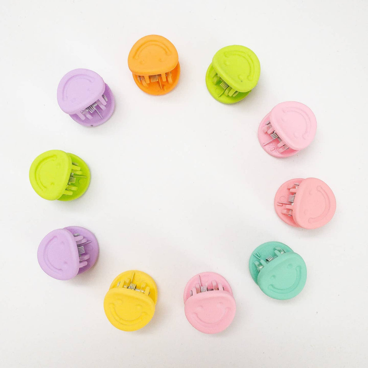 Colorful hair clips arranged on a white background