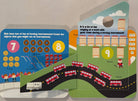 A children's interactive counting toy book with hockey-themed pages, showing numbers 7 through 9 with illustrated objects like skates, hockey pucks, sticks, and buses on a curved road.