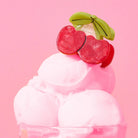Ice cream cone with cherry and banana on a pink background