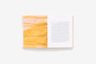 Open book with yellow marbled pages and white text on a white background