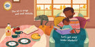 A warm illustrated family scene shows a father and child reading under blankets in a cozy room, with a table holding a bottle, apples, cups, plates, and a pie, plus a cat by the window. Text overlays read, 'The air is crisp and cool outside.