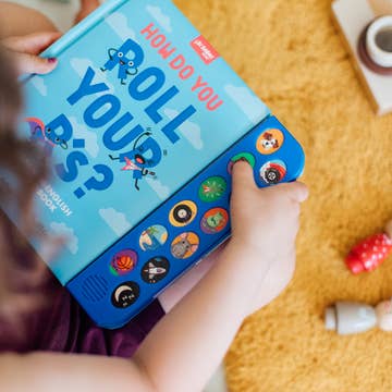 Children's book titled 'How Do You Roll Your R's?' with colorful buttons on a yellow cushion.