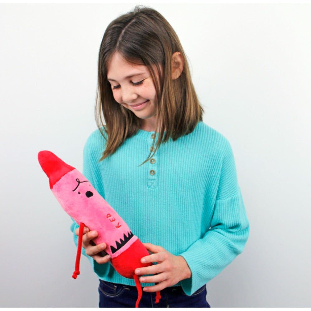 Girl holding a pink and red toy resembling a lipstick against a plain background