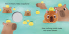 An illustrated spread from "Baby Capybara - Finger Puppet Book" showing several capybaras relaxing in a hot spring with yuzu fruit on their heads, alongside a finger hole and text that reads "How brilliant, Baby Capybara!" and "Now nothing could make this onsen better...".