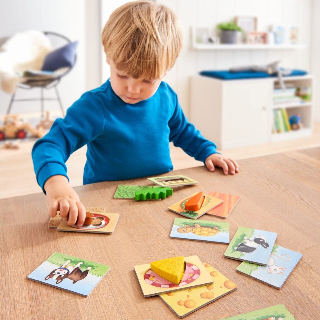Child playing with educational cards on a wooden table