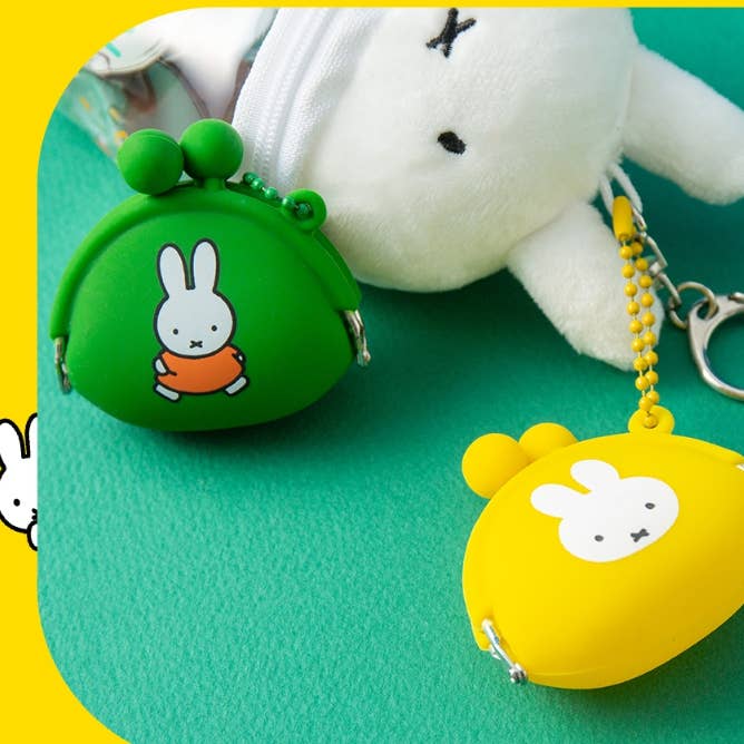 Two small silicone coin purses, one green and one yellow, with cartoon character designs on a teal background.
