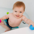 Baby playing with bath toys in a bathtub