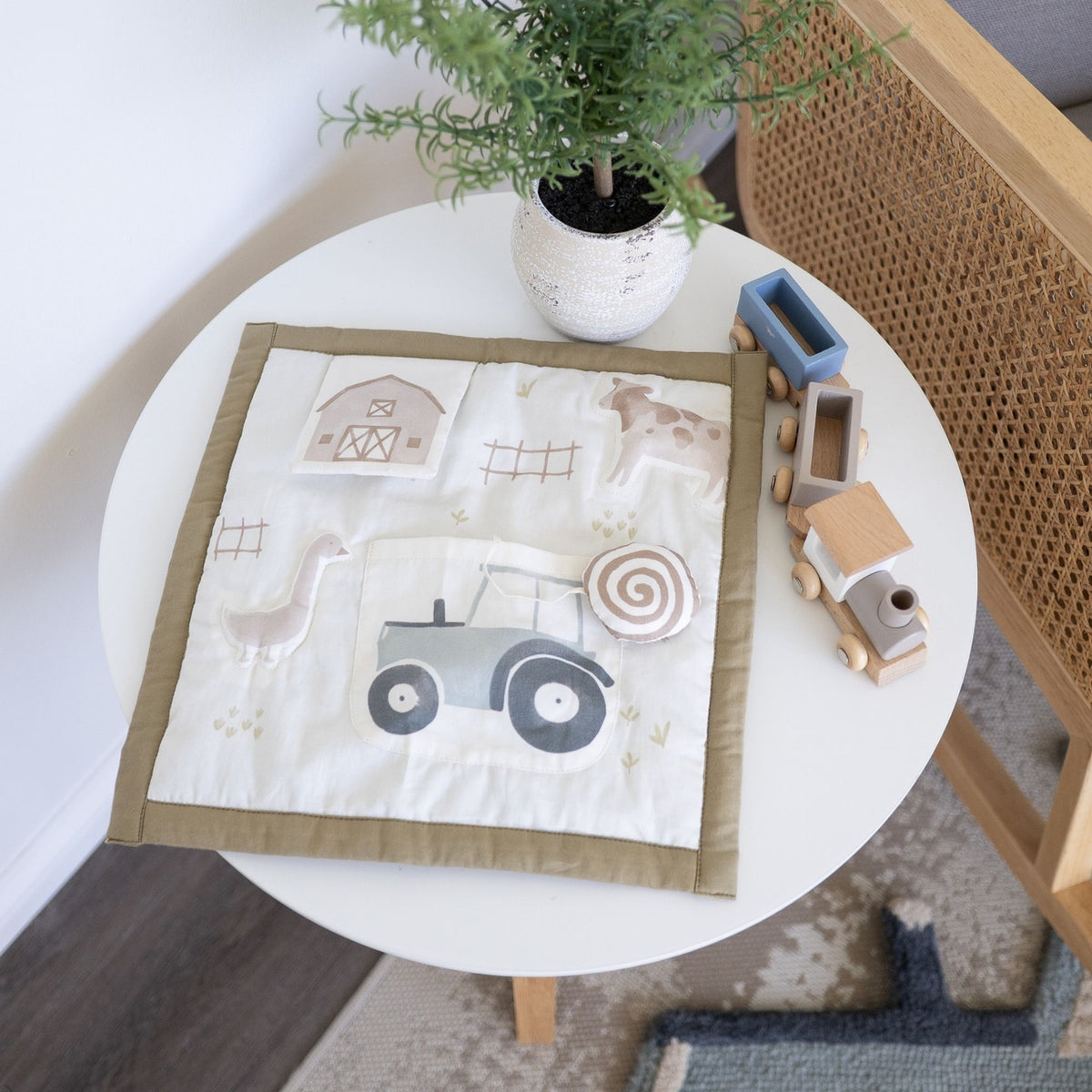 Children's play mat with farm-themed design on a round white table.