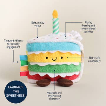 Plush toy cake with candle labeled for features on a beige background
