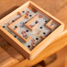 Wooden maze toy with cars on a wooden surface