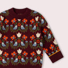 Maroon sweater with colorful bird and floral pattern on a white background