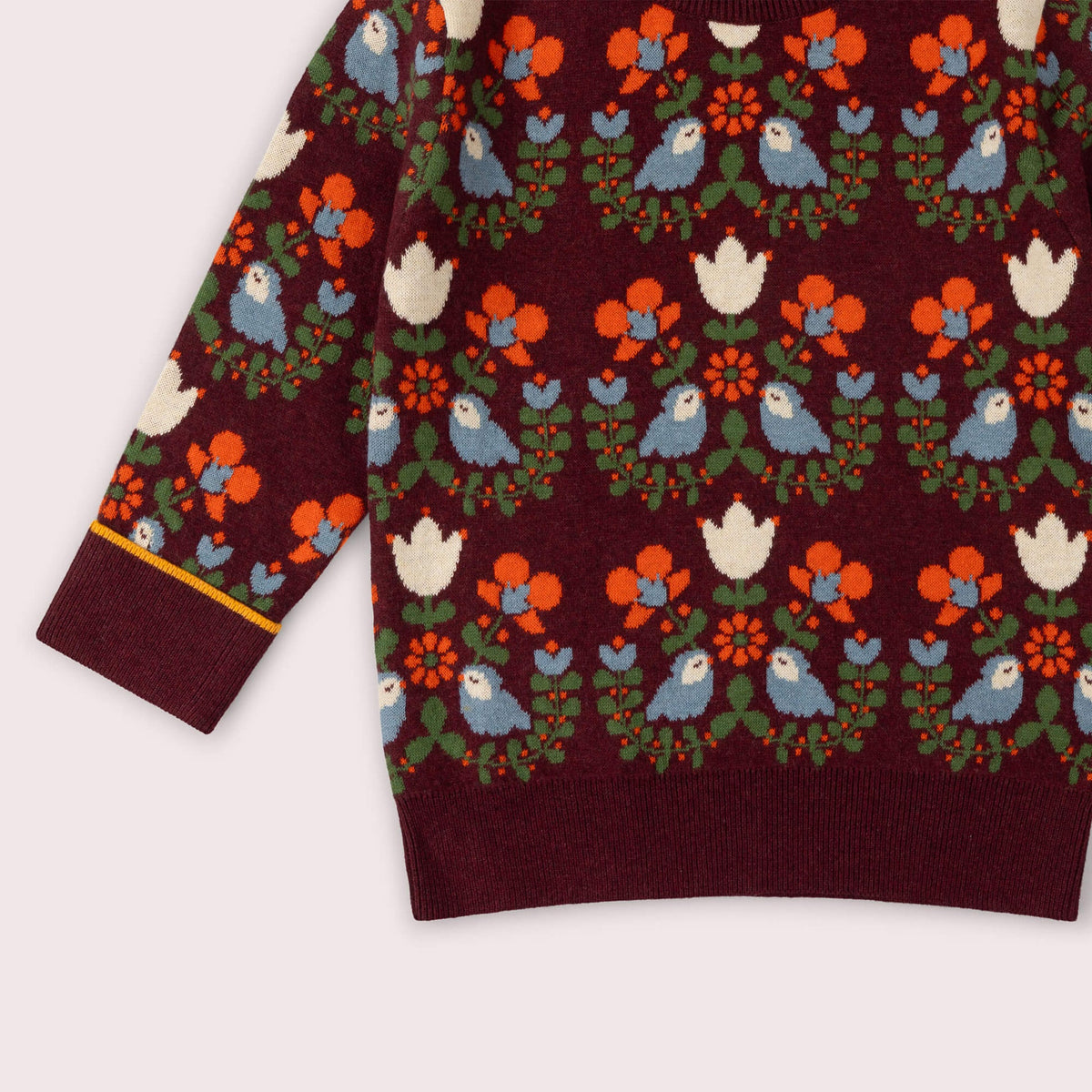 Maroon sweater with colorful bird and floral pattern on a white background