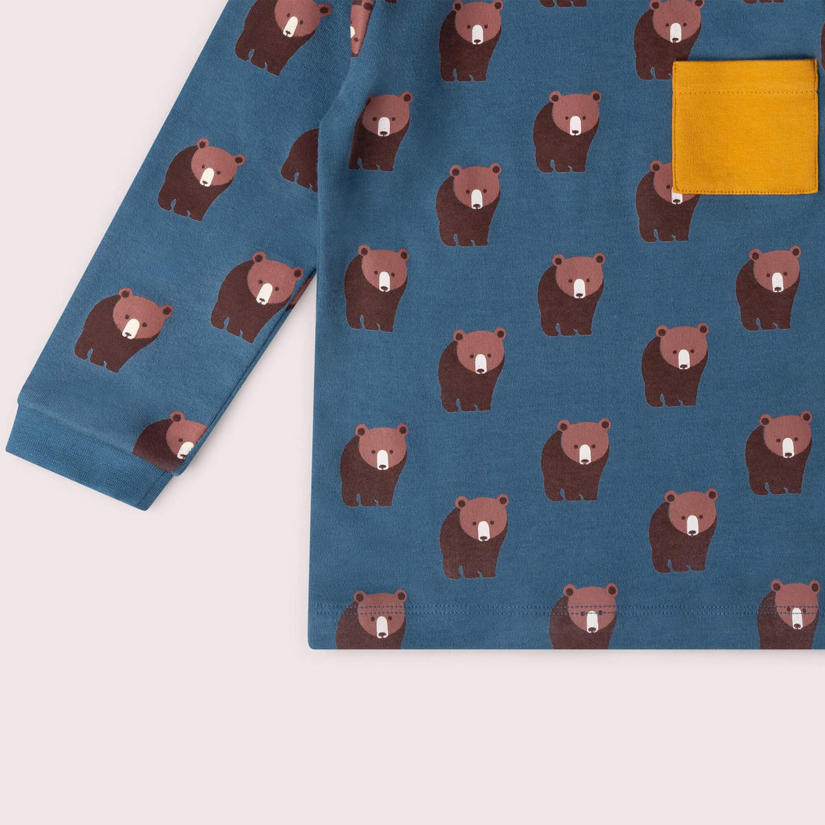 A long-sleeve shirt with bear pattern and yellow pocket on a light gray background