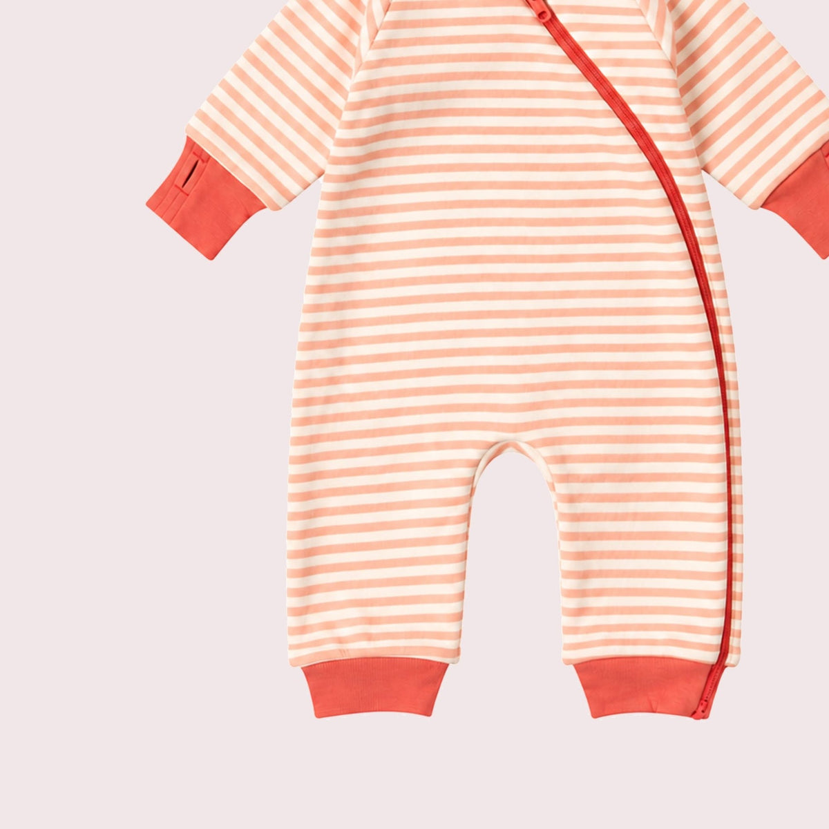 A baby long-sleeve footless romper with horizontal peach and white stripes, featuring solid peach cuffs and a peach side zipper, shown on a light pink background.