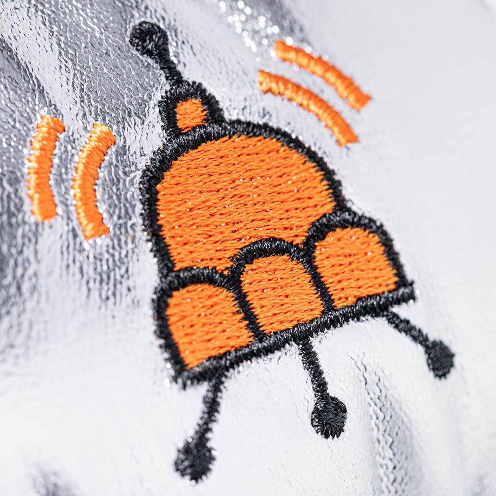 Embroidered design of a bee on a white fabric background