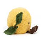Plush lemon toy with green leaves and brown stem on a white background