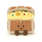 A plush toy shaped like a treasure chest with a smiling face, featuring yellow faux fur inside, brown and beige fabric textures, and small colorful gem accents on a plain white background.