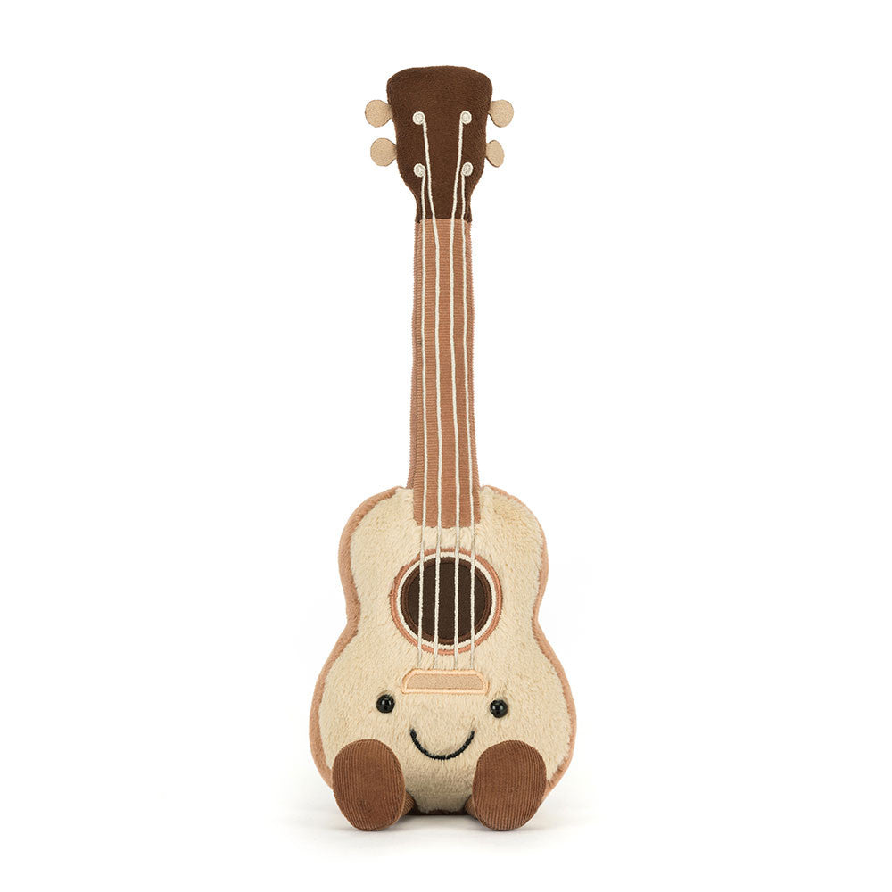A plush toy ukulele with a smiling face, primarily beige in color with a brown headstock and bridge, and a happy facial expression.