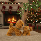 Two plush cats in a festive setting with a fireplace and Christmas tree.