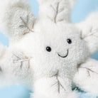 White plush toy with a smiling face against a light blue background