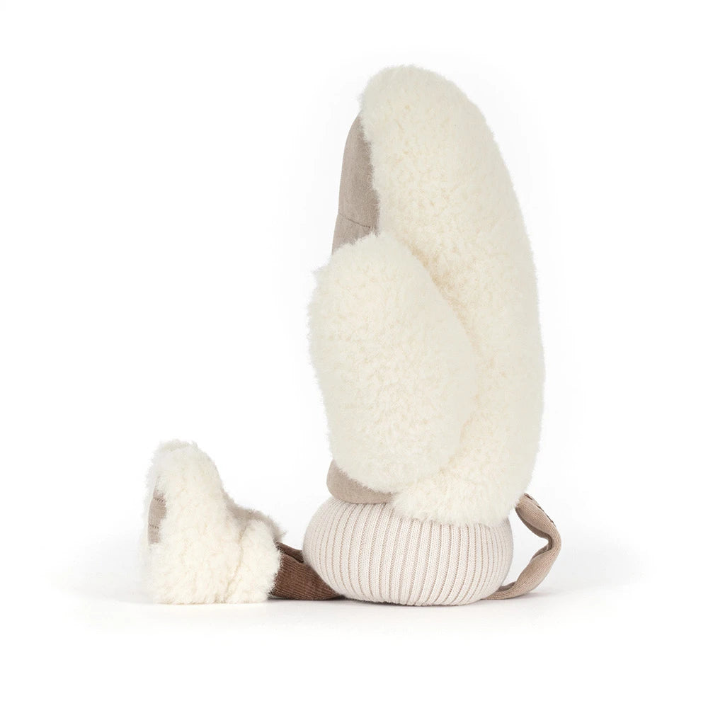 A plush sheepskin bootie with a ribbed knit cuff in beige, photographed on a seamless white background.