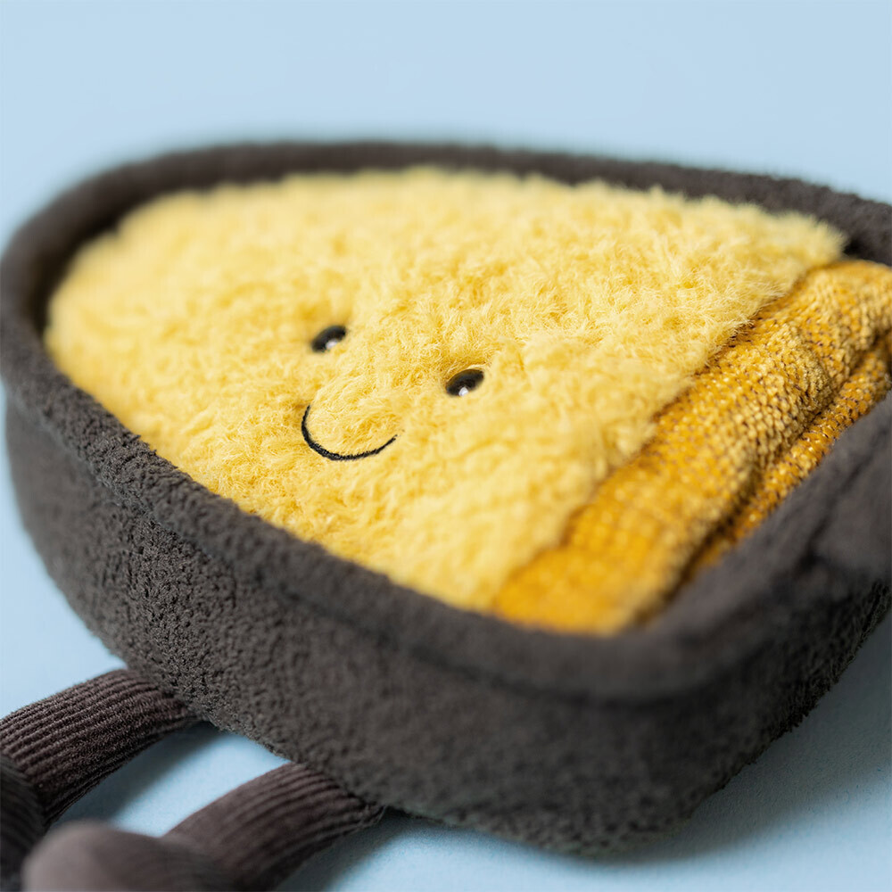 Plush toy resembling a slice of bread with a smiley face on a light blue background